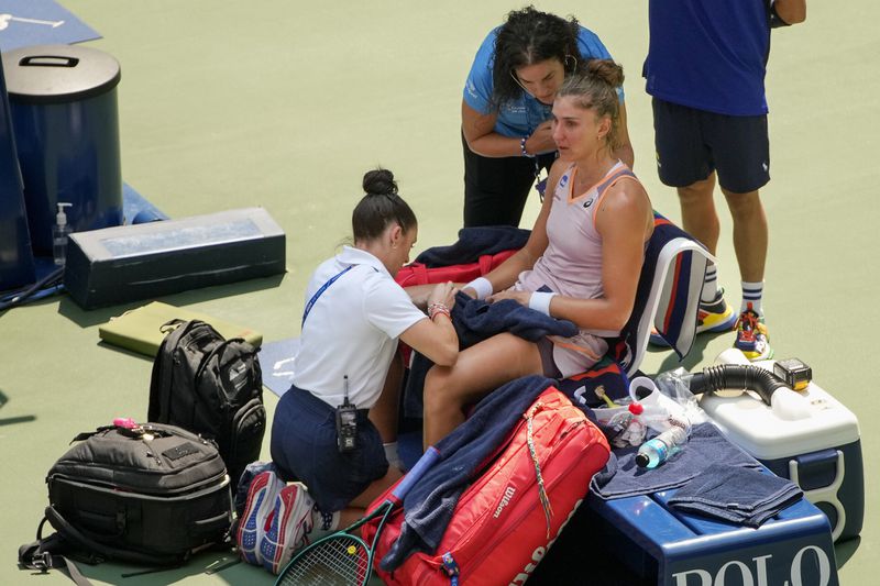 Beatriz Haddad Maia, of Brazil, is checked by medical personnel during the second set against Karolina Muchova, of the Czech Republic, during the quarterfinals of the U.S. Open tennis championships, Wednesday, Sept. 4, 2024, in New York. (AP Photo/Kirsty Wigglesworth)