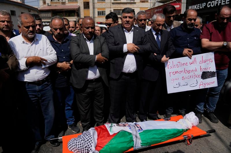 Mourners pray over the body of Aysenur Ezgi Eygi, 26, who was fatally shot by Israeli soldiers while participating in an anti-settlement protest in the West Bank, during her funeral procession in the West Bank city of Nablus, Monday, Sept. 9, 2024. (AP Photo/Nasser Nasser)