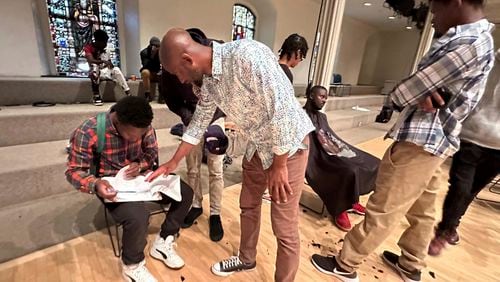 Mamadou Diallo, 39, of Senegal, as he maintains the list of fellow migrants who are waiting to get a haircut at the "welcome center" at St. Mark's Church-in-the-Bowery, a lower Manhattan Episcopal church, Wednesday, May 22, 2024, in New York. Diallo is among the migrants that are hitting their 30 day time limit in the shelter this week. (AP Photo/Philip Marcelo)