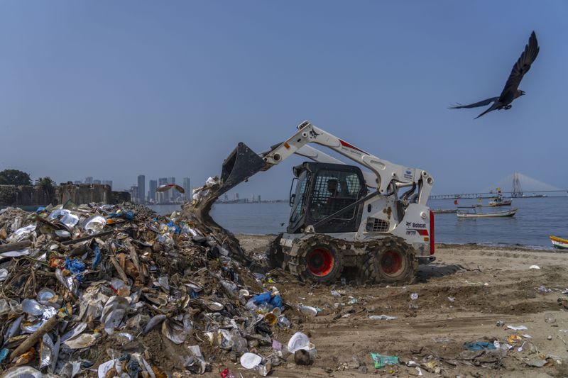 FILE - An excavator cleans up plastic and other waste materials on Mahim Beach on the Arabian Sea coast on Earth Day in Mumbai, India, April 22, 2024. (AP Photo/Rafiq Maqbool, File)