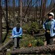 Marin Chambers, left, takes notes while Maddie Wilson provides observations Tuesday, June 11, 2024, in Bellvue, Colo, at a reforestation test plot at the 2020 Cameron Peak Fire burn area. (AP Photo/Brittany Peterson)