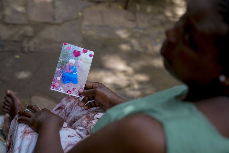 Priscillar Riziki holds a photo of her daughter, Lorine Menza, a member of the Good News International Church cult now presumed dead, at her home in the coastal city of Malindi, in southern Kenya, on Saturday, Sept. 7, 2024. (AP Photo/Brian Inganga)