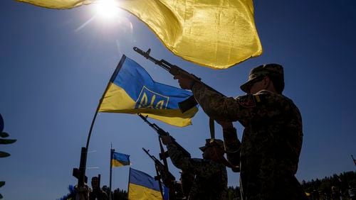 Honor guards shoot into the air during the funeral ceremony of six Ukrainian servicemen killed in a Russian rocket attack at a Ukrainian military academy, during their funeral ceremony in Poltava, Ukraine, Saturday Sept. 7, 2024. (AP Photo/Evgeniy Maloletka)