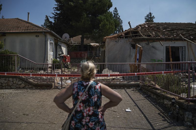 A woman looks at a damaged house that was hit by a rocket fired from Lebanon, near Safed, northern Israel, on Wednesday, Sept. 25, 2024. (AP Photo//Leo Correa)