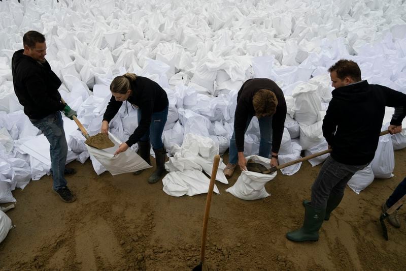 People fill sandbags to reinforce the dam due to the flooding of the Danube river at Tahitotfalu, Hungary, on Monday, Sept. 16, 2024. (AP Photo/Denes Erdos)