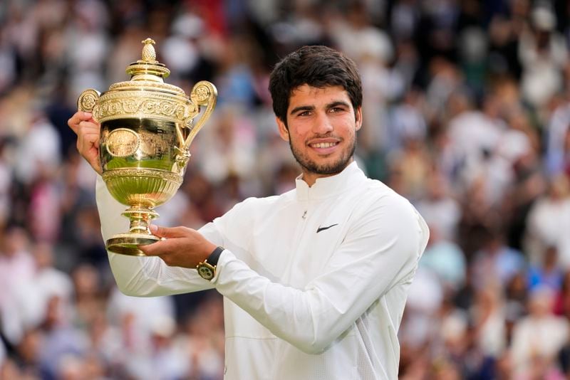 FILE - Spain's Carlos Alcaraz celebrates with the trophy after beating Serbia's Novak Djokovic to win the final of the men's singles on day fourteen of the Wimbledon tennis championships in London, Sunday, July 16, 2023. This year's Wimbledon tournament begins on Monday, July 1.(AP Photo/Kirsty Wigglesworth, File