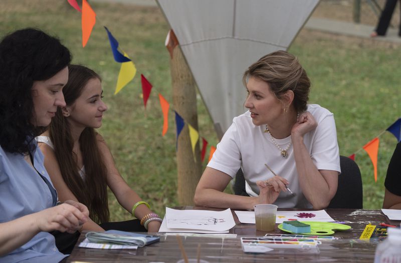 First lady Olena Zelenska talks to a girl during her visit to the rehabilitation camp "Loud Camp" for children affected by war, organized by the Voices of Children Charitable Foundation and financially supported by the Olena Zelenska Foundation in Uzhhorod, Ukraine, Tuesday, Aug. 27, 2024. (AP Photo/Efrem Lukatsky)