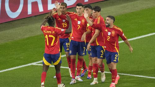 Spain's Alvaro Morata celebrates with teammates after Italy's Riccardo Calafiori, right, lies face down on the pitch after scoring an own goal during a Group B match between Spain and Italy at the Euro 2024 soccer tournament in Gelsenkirchen, Germany, Thursday, June 20, 2024. (AP Photo/Andreea Alexandru)
