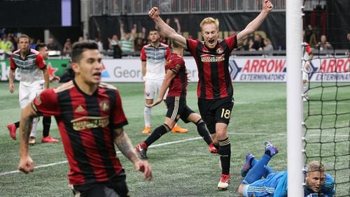 Atlanta United midfielder Jeff Larentowiz (center) and teammates react as a shot by teammate Hector Villalba (far left) gets past D.C. United goalkeeper David Ousted for a 3-0 lead during the second half Sunday, March 11, 2018, in Atlanta. Atlanta United won the game 3-1.