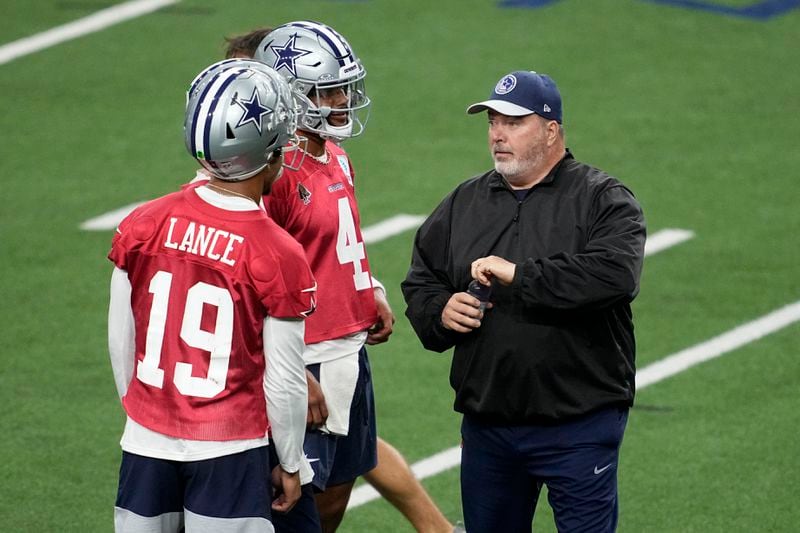 Dallas Cowboys quarterbacks Trey Lance (19) and Dak Prescott (4) talk with head coach Mike McCarthy during an NFL football practice at the team's training facility, Wednesday, Aug. 28, 2024, in Frisco, Texas. (AP Photo/Tony Gutierrez)