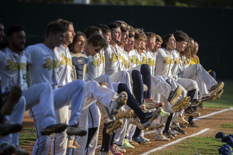 FILE- The Savannah Bananas line up along the first base line to perform a kick-line dance before a Coastal Plain League baseball game against the Florence Flamingos, June 7, 2022, in Savannah, Ga. (AP Photo/Stephen B. Morton, File)