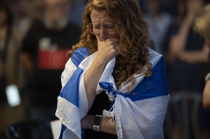 A woman closes her eyes during a vigil in memory of slain hostage Hersh Goldberg-Polin in Jerusalem, Israel, Sunday, Sept. 1, 2024. (AP Photo/Leo Correa)