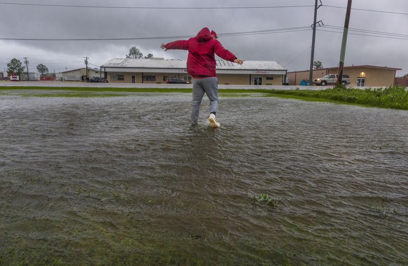 Having never before experienced the powerful forces of a hurricane, meteorologist Max Claypool of Memphis, Tenn. tries to see if the powerful winds blowing from the Hurricane Francine eye wall could lift him further in the air on Wednesday, Sept.11, 2024, Houma, La. (Chris Granger/The Times-Picayune/The New Orleans Advocate via AP)