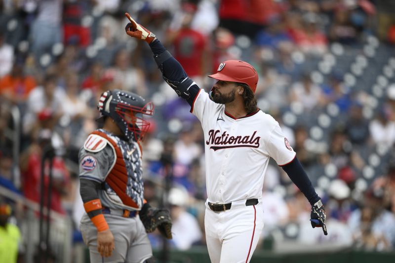Washington Nationals' Jesse Winker, right, celebrates his home run during the eighth inning of a baseball game against the New York Mets, Thursday, July 4, 2024, in Washington. New York Mets catcher Francisco Alvarez looks on at back left. The Nationals won 1-0. (AP Photo/Nick Wass)