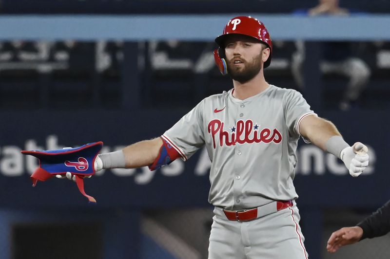 Philadelphia Phillies' Kody Clemens (12) gestures toward the dugout after hitting a double in the ninth inning of a baseball game against the Toronto Blue Jays in Toronto on Tuesday, Sept. 3, 2024. (Jon Blacker/The Canadian Press via AP)