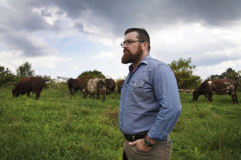 The Rev. Lee Scott stands in the pasture with his cows at Laurel Oak Farm in Butler, Pa., on Friday, Sept. 6, 2024. (AP Photo/Jessie Wardarski)