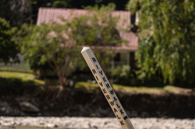 A road sign sticks in the mud where a road was in the aftermath of Hurricane Helene, Wednesday, Oct. 2, 2024, in Chimney Rock Village, N.C. (AP Photo/Mike Stewart)