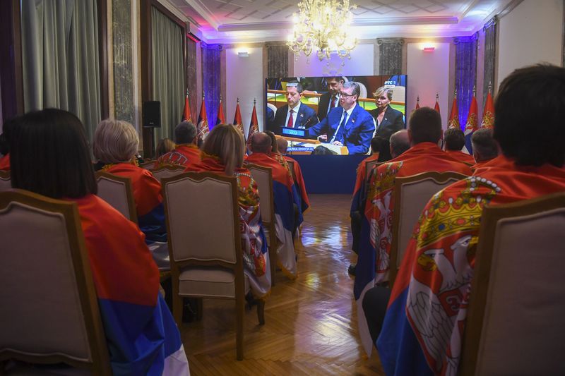 In this photo provided by the Serbian Presidential Press Service, members of Serbia's government wrapped in Serbian flags as they watch the vote in the U.N. that established an annual commemoration of the 1995 genocide of Bosnia's Muslims by the Bosnian Serbs in Belgrade, Serbia, Thursday, May 23, 2024. (Serbian Presidential Press Service via AP)