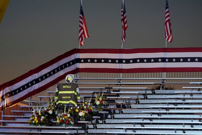 A memorial for firefighter Corey Comperatore, who died as he shielded family members from gunfire, is seen in the bleachers before Republican presidential nominee former President Donald Trump speaks at the Butler Farm Show, the site where a gunman tried to assassinate him in July, Saturday, Oct. 5, 2024, in Butler, Pa. (AP Photo/Alex Brandon)