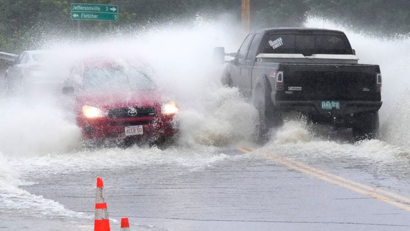 Vehicles drive through high water from the Lamoille River covering Route 15 after remnants of Hurricane Beryl caused flooding, Thursday, July 11, 2024, in Cambridge, Vt. (AP Photo/Charles Krupa)