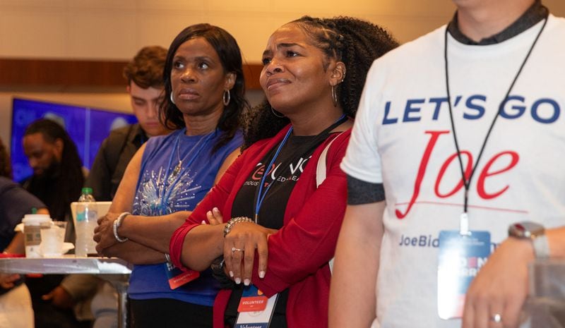 Sharon Bates (left) of South Fulton, and Akilah Raines (center) react during the presidential debate at a gathering for Democrats in Atlanta.