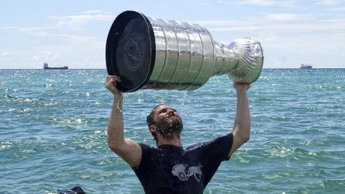 Florida Panthers NHL hockey player Matthew Tkachuk celebrates with the Stanley Cup in the Atlantic Ocean in Fort Lauderdale, Fla., Tuesday, June 25, 2024. The Panthers beat the Edmonton Oilers 2-1 on Monday night in Game 7 of the Stanley Cup Final. (Joe Cavaretta/South Florida Sun-Sentinel via AP)