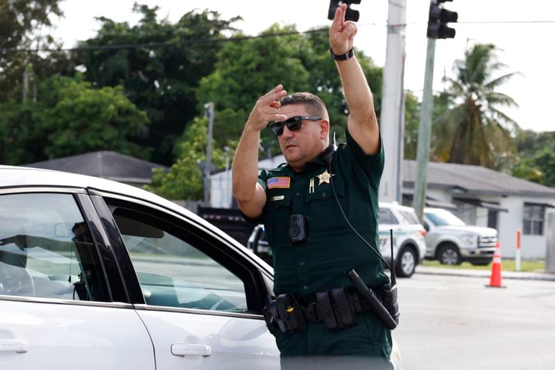 A police officer directs traffic near Trump International Golf Club after the apparent assassination attempt of Republican presidential nominee former President Donald Trump in West Palm Beach, Fla., Sunday, Sept. 15, 2024. (AP Photo/Terry Renna)