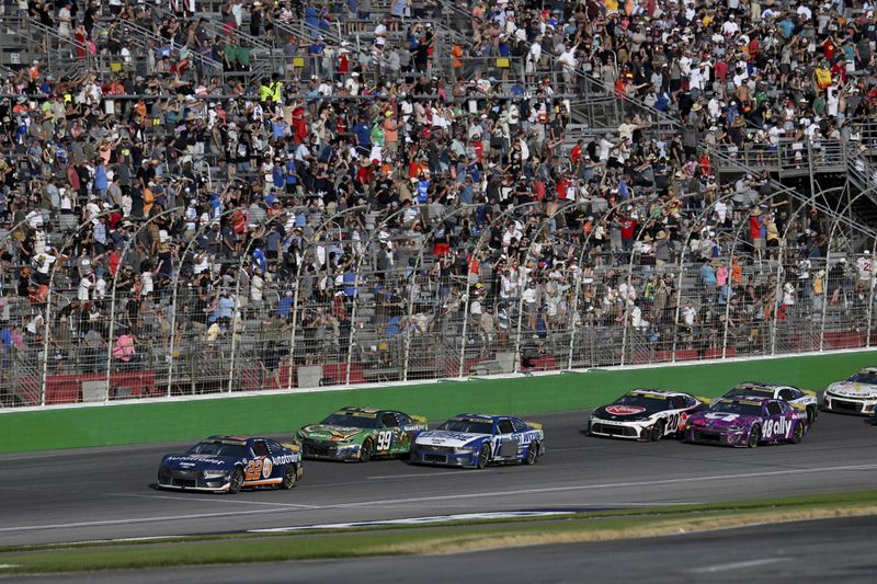 Joey Logano (22) leads a line of cars during a NASCAR Cup Series auto race at Atlanta Motor Speedway, Sunday, Sept. 8, 2024, in Hampton, Ga. (Hyosub Shin/Atlanta Journal-Constitution via AP)