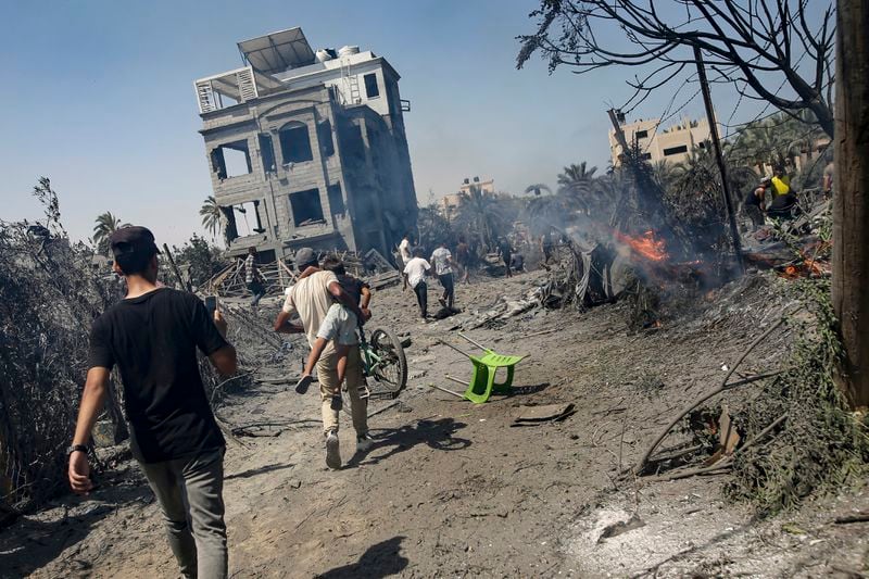 Palestinians evacuate from a site hit by an Israeli bombardment on Khan Younis, southern Gaza Strip, Saturday, July 13, 2024. Israel said it targeted Hamas' shadowy military commander in a massive strike Saturday in the crowded southern Gaza Strip that killed at least 71 people, according to local health officials. Hamas immediately rejected the claim that Mohammed Deif was targeted. (AP Photo/Jehad Alshrafi)