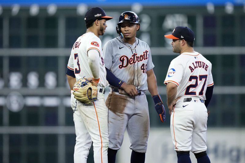 Detroit Tigers' Wenceel Pérez, center, talks with Houston Astros shortstop Jeremy Peña (3) and second baseman Jose Altuve (27) during a video review during the seventh inning of Game 1 of an AL Wild Card Series baseball game, Tuesday, Oct. 1, 2024, in Houston. (AP Photo/Kevin M. Cox)