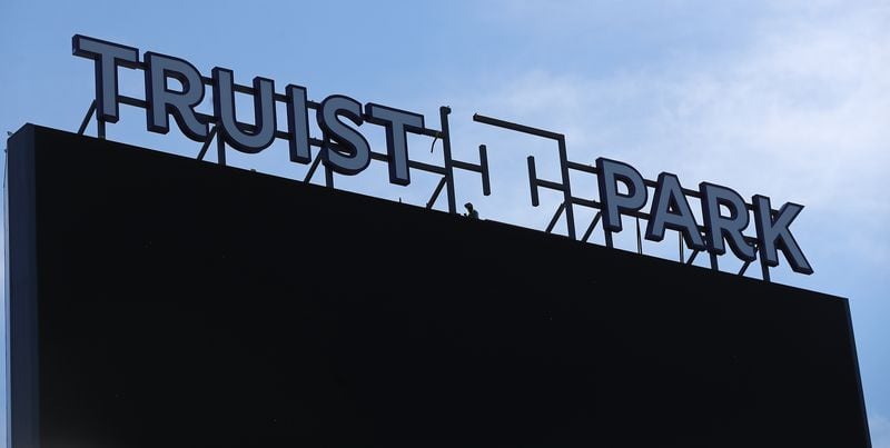  A constuction worker installs the new sign over the center -field scoreboard/video board at newly renamed Truist Park.  