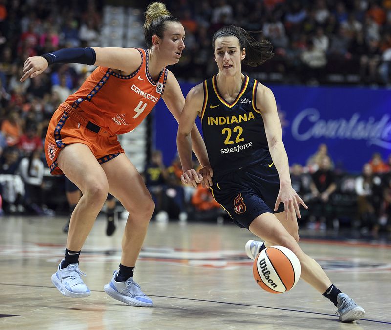 Connecticut Sun's Marina Mabrey (4) guards against Indiana Fever's Caitlin Clark (22) during a first-round WNBA basketball playoff game at Mohegan Sun Arena, Sunday, Sept. 22, 2024. (Sarah Gordon/The Day via AP)