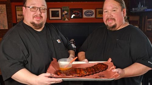 240620 Brookhaven, Ga: Brothers Justin (glasses) and Jonathan Fox, co-owners of Atlanta-based Fox Brothers Barbecue, show how to use their ÒBrookhaven Rib GlazeÓ - (note the glazeÕs title may change according to Jonathan Fox) on a rack of BBQ Baby Back Ribs at their recently opened Brookhaven location at, 4058 Peachtree Road, Brookhaven Ga. 30319. Photo for AJC Food section story on Marinades, by C.W. Cameron. Photos taken Thursday June 20, 2024. Food styling by Jonathan and Justin Fox. 071424MARINADES (CHRIS HUNT FOR THE ATLANTA JOURNAL-CONSTITUTION)