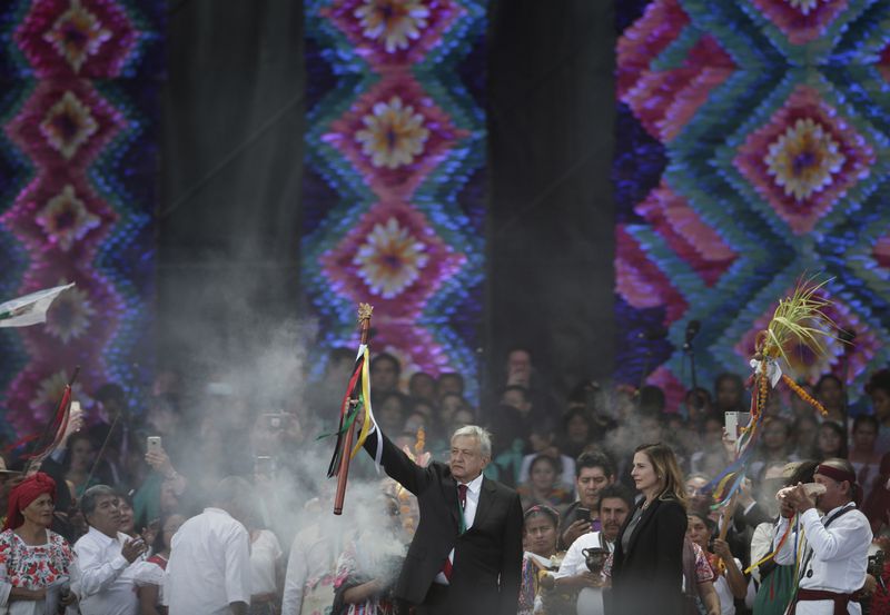 FILE - Newly elected President Andres Manuel Lopez Obrador holds a chieftain's staff during an Indigenous ceremony at the Zocalo in Mexico City, Dec. 1, 2018. (AP Photo/Eduardo Verdugo, File)