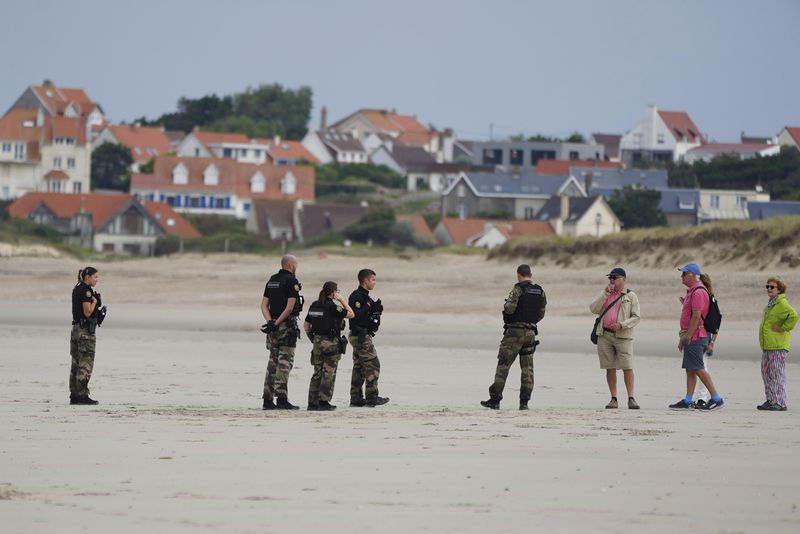 Police officers guard on the Wimereux beach, France, Wednesday, Sept. 4, 2024. A boat carrying migrants ripped apart in the English Channel as they attempted to reach Britain from northern France on Tuesday, plunging dozens into the treacherous waterway and leaving 12 dead, authorities said. (AP Photo/Nicolas Garriga)