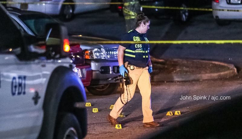 A GBI agent lays evidence makers in the parking lot of the Home Stay Suites in Riverdale on Monday morning. 