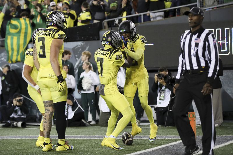 Oregon Ducks wide receiver Tez Johnson, right, celebrates after scoring a touchdown with teammates Dillon Gabriel, Terrance Ferguson, and Evan Stewart during the second half of an NCAA college football game, Friday, Oct. 4, 2024, in Eugene, Ore. (AP Photo/Amanda Loman)