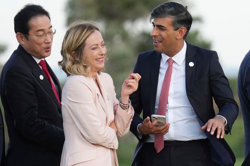 Japan's Prime Minister Fumio Kishida, British Prime Minister Rishi Sunak and Italian Prime Minister Giorgia Meloni, right, gather to watch a parachute drop at San Domenico Golf Club on the first day of a G7 world leaders summit, at Borgo Egnazia, southern Italy, Thursday, June 13, 2024. (Christopher Furlong/Pool Photo via AP)