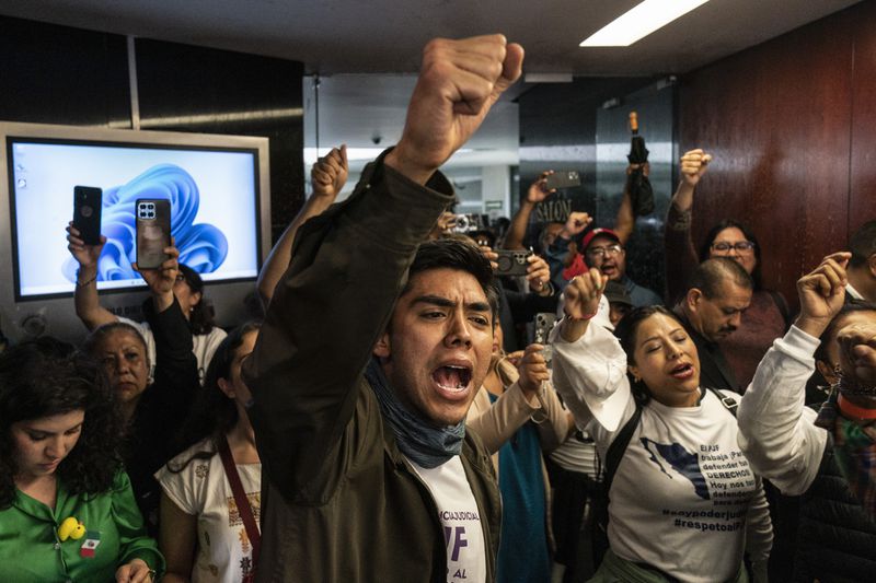 Protesters attempt to break into a room in the Senate as lawmakers weigh the government's proposed judicial reform, which would make judges stand for election, in Mexico City, Tuesday, Sept. 10, 2024. (AP Photo/Felix Marquez)