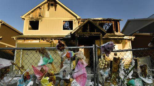 FILE - The house where five Senegalese immigrants were murdered in a fire is surrounded by old bouquets, stuffed animals and other remembrances, Jan. 27, 2021, in Denver. Kevin Bui has been sentenced to 60 years in prison, Tuesday, July 2, 2024, after pleading guilty to murder charges for starting the 2020 fire. (Helen H. Richardson/The Denver Post via AP, File)
