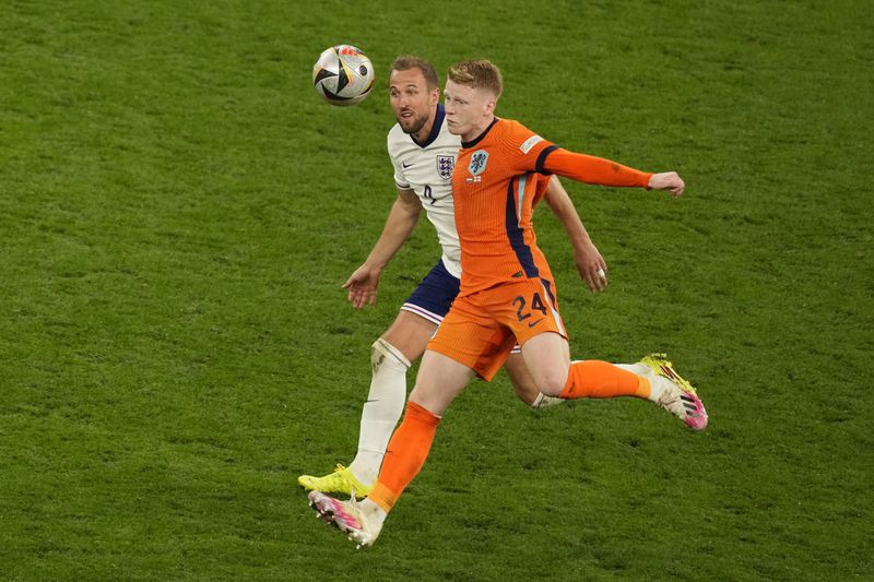 England's Harry Kane challenges for the ball with Jerdy Schouten of the Netherlands during a semifinal match between the Netherlands and England at the Euro 2024 soccer tournament in Dortmund, Germany, Wednesday, July 10, 2024. (AP Photo/Andreea Alexandru)