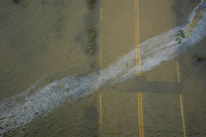An oil slick drifts across the surface as the storm surge from Tropical Storm Alberto floods streets, Wednesday, June 19, 2024, in Surfside Beach, Texas. ( Jon Shapley/Houston Chronicle via AP)