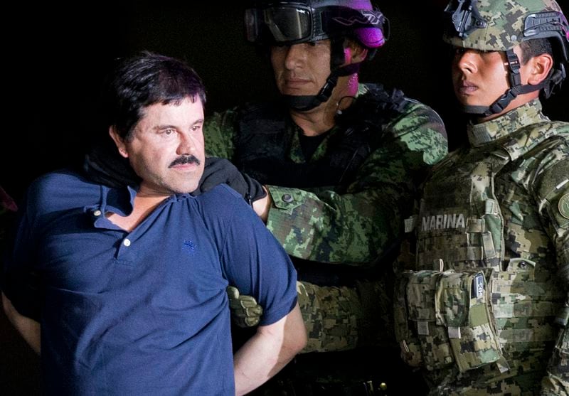 FILE - A handcuffed Joaquin "El Chapo" Guzman is made to face the press as he is escorted to a helicopter by Mexican soldiers and marines at a federal hangar in Mexico City, Jan. 8, 2016. (AP Photo/Eduardo Verdugo, File)