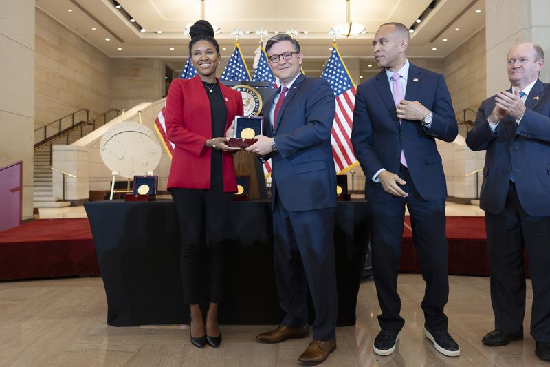 House Speaker Mike Johnson, R-La., center, stands with Dr. Christon Darden, left, to present a Congressional Gold Medal on behalf of her grandmother Christine Darden as they honor the Black women mathematicians of NASA who contributed to the space race and who were the subject of the book and movie "Hidden Figures," at the Capitol in Washington, Wednesday, Sept. 18, 2024. They are joined by House Minority Leader Hakeem Jeffries, D-N.Y., second from right, and Sen. Chris Coons, D-Del. (AP Photo/J. Scott Applewhite)