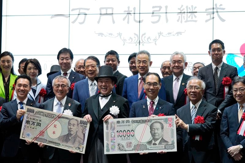 Officials pose with enlarged copies of the new and old 10000 yen banknotes during the "10,000 Yen Bill Handover Ceremony" at Tokyo Stock Exchange Wednesday, July 3, 2024, in Tokyo. New 10000 yen bill featuring a portrait of local figure Shibusawa Eiichi, the "father of Japanese capitalism." From Fukaya City. Nakatsu City is where Yukichi Fukuzawa, a figure of previous 10000 yen bill, was from. (AP Photo/Eugene Hoshiko)