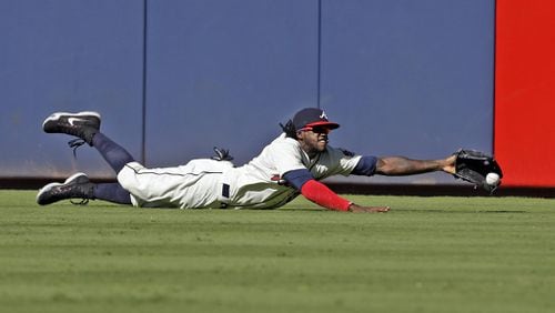 Braves center fielder Cameron Maybin just misses a fly ball from the Mets’ Juan Lagares as Maybin dives for it during the ninth inning Sunday, Sept. 13, 2015, at Turner Field. (AP Photo/Butch Dill)
