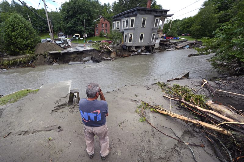 Rick Gordon, of Plainfield, Vt. looks at what remains of Mill Street and an apartment building after remnants of Hurricane Beryl caused flooding and destruction, Friday, July 12, 2024, in Plainfield. (AP Photo/Charles Krupa)