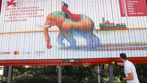 Workers paint signage for the 81st edition of the Venice Film Festival in Venice, Italy, on Tuesday, Aug. 27, 2024. The festival runs from Aug. 27 until Sept. 8. (Photo by Vianney Le Caer/Invision/AP)