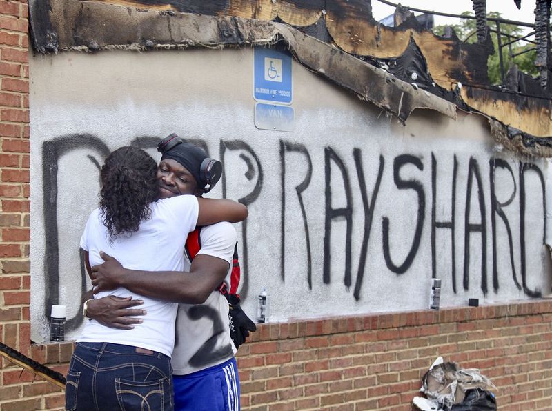 Eva Snow and Joseth Jett hug after Jett spray-painted over the top of graffiti from the night before and painted RIP Rayshard. People began showing up at Wendy's on University Avenue Sunday morning, June 14, 2020.  Some helped with cleanup, some came to look, and some began placing flowers and created a memorial.  On Saturday, protesters set fire to the Atlanta Wendy's where Rayshard Brooks, a 27-year-old black man,  was shot and killed by Atlanta police Friday evening during a struggle at a Wendy's drive-thru line. (Photo: Steve Schaefer for The Atlanta Journal-Constitution)