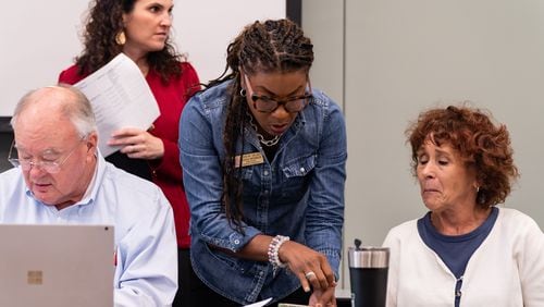 Cobb County Board of Elections chair Tori Silas, center, and assistant secretary Debbie Fisher, right, talk before a board meeting at the Cobb County Safety Village in Marietta, GA on Saturday, August 3, 2024.